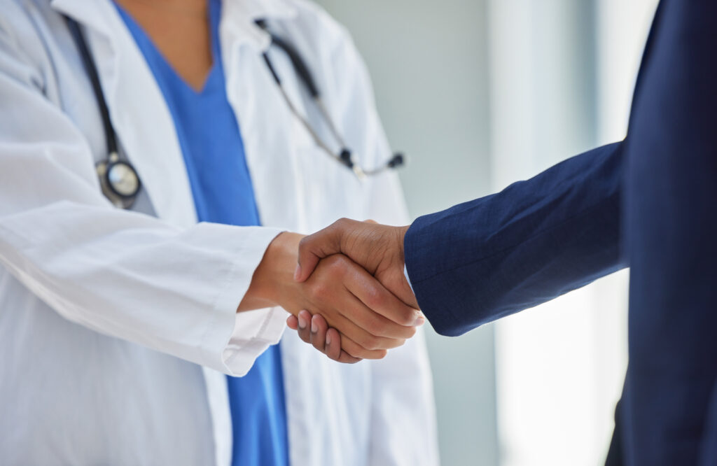 Cropped shot of a doctor shaking hands with a businessman in a hospital